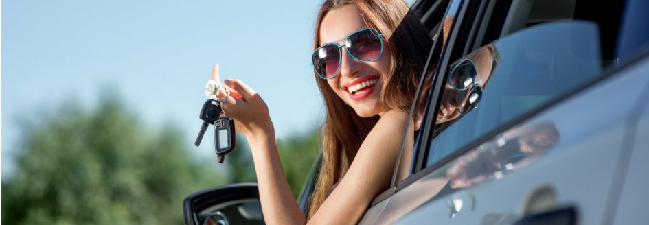 Woman in sunglasses dangling car keys out of window